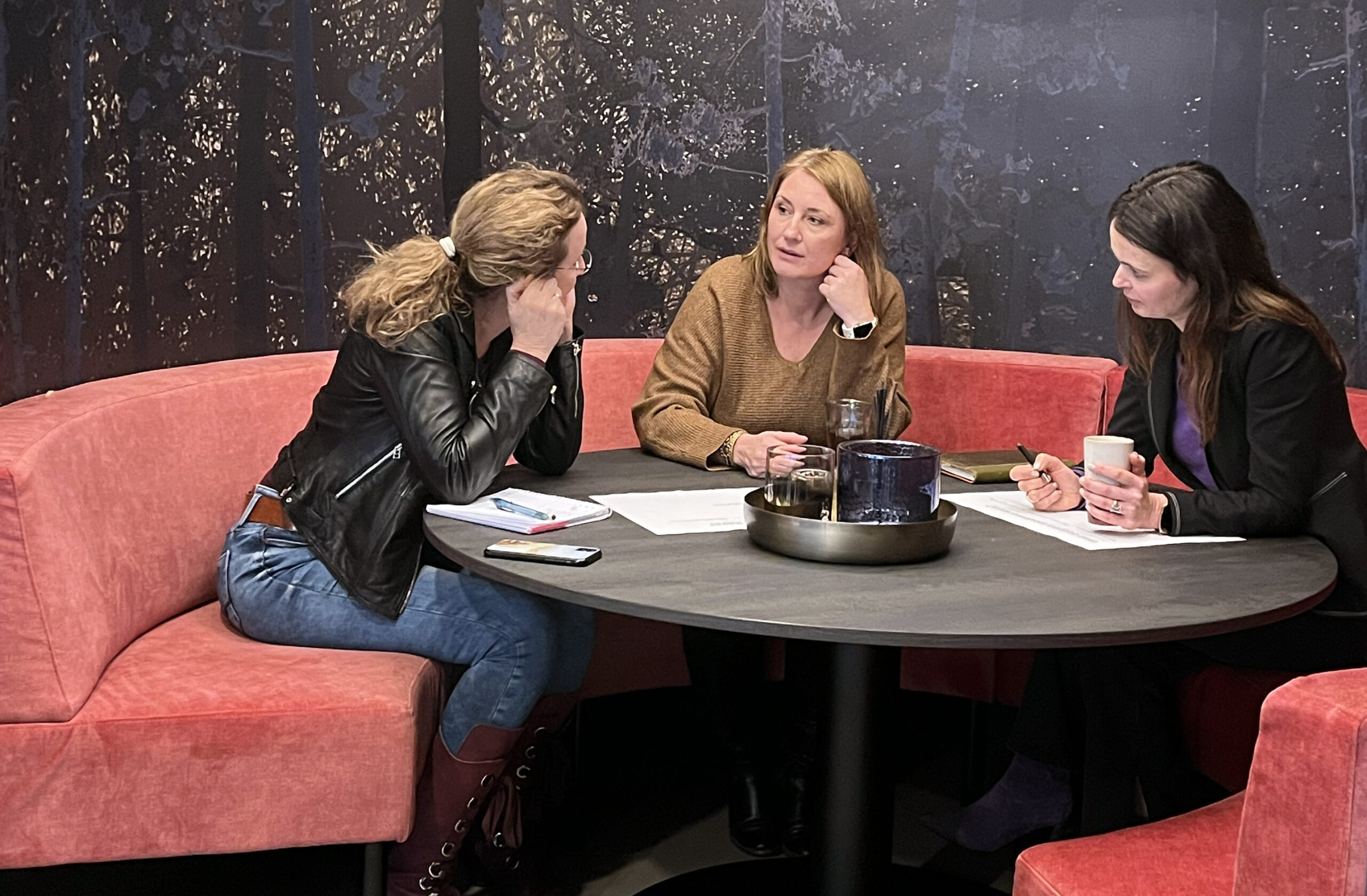 Groep mensen gebogen over vellen papier tijdens een schrijftraining bij Einder.